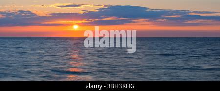 Un large coucher de soleil panoramique avec vue sur l'océan Atlantique vu de la ville d'Etretat, Normandie, France. Banque D'Images