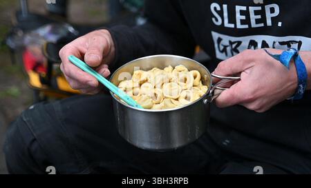 Nuremberg, Allemagne. 07 juin 2025. Un festivalier mange des tortellini dans un pot de camping au festival en plein air 'Rock im Park' à Nuremberg. Crédit : Leonie Asendorpf/dpa/Alamy Live News Banque D'Images