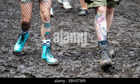 Nuremberg, Allemagne. 07 juin 2025. Un festivalier se promène dans la boue au festival en plein air « Rock im Park » de Nuremberg. Crédit : Leonie Asendorpf/dpa/Alamy Live News Banque D'Images