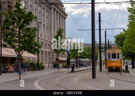 Budapest, Hongrie - 24 mai 2025 : arrêt du tramway rétro près du Parlement avec un flou de mouvement dynamique Banque D'Images