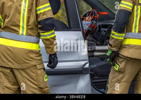 Les pompiers et les sauveteurs ont ouvert une carrosserie de voiture lors d'une opération de sauvetage, le lieu d'un accident de la route Banque D'Images