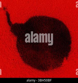 Graffiti bombe noire avec une mèche brûlante. Icône de bombe sur le mur rouge Banque D'Images