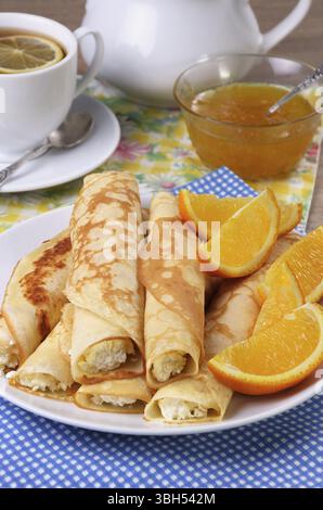 Crêpes farcies au fromage cottage et des oranges pour le petit déjeuner Banque D'Images