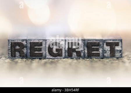 Le mot REGRET écrit en typographie teintée à l'encre vintage Banque D'Images