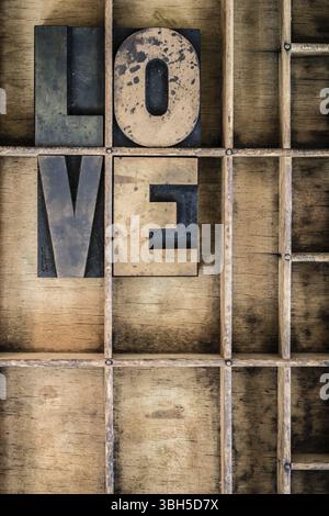 Le mot LOVE écrit en typographie vintage en bois dans un tiroir diviseur en bois Banque D'Images
