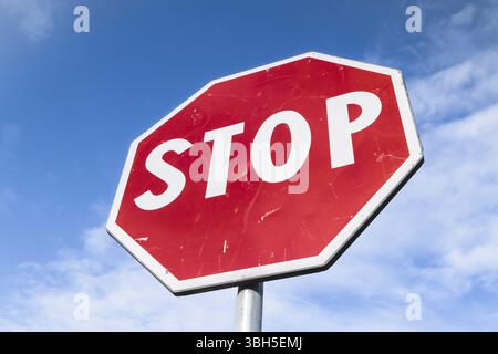 Stop panneau routier sur un fond de ciel bleu avec des nuages blancs Banque D'Images