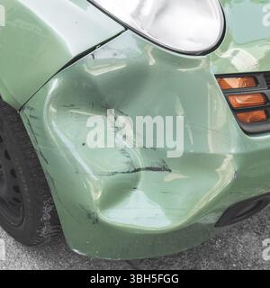 Voiture bosselée verte. La carrosserie latérale de la voiture a été endommagée par accident dans la circulation. Gros plan Banque D'Images