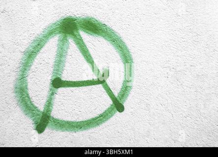 Symbole d'anarchie vert sur le mur. Idéal pour les textures, les arrière-plans et les concepts. Copier l'espace Banque D'Images