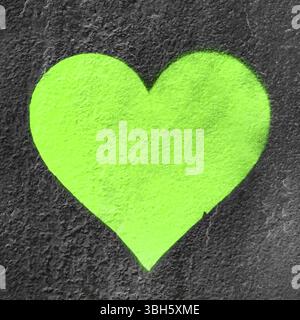 Cœur urbain vert. Fluo Love Heart main dessinée sur le mur grungy. Fond texturé style de rue tendance Banque D'Images