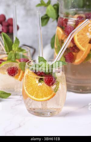 Cocktail Sangria d'été ou limonade à la framboise, orange et menthe. Rafraîchissant bio sans alcool, boisson saine vitaminée Detox, fruits dans un in Banque D'Images