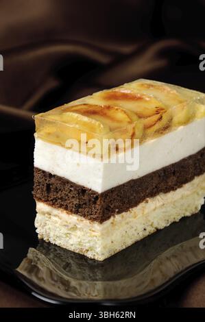 Empilées de gâteau au caramel, chocolat, mousse de pomme et amande biscuit avec une couche de gelée de pommes caramélisées tranches Banque D'Images