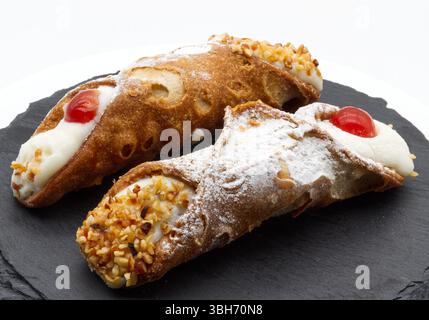 Deux délicieux Cannoli Siciliani italiens sur une assiette en ardoise sombre Banque D'Images