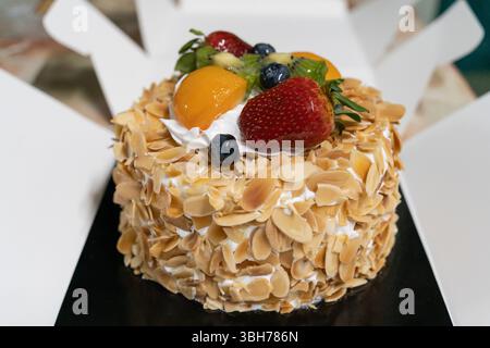 Il s'agit d'une vue rapprochée d'un gâteau à la crème de fruits et d'amandes avec la boîte ouverte. Banque D'Images