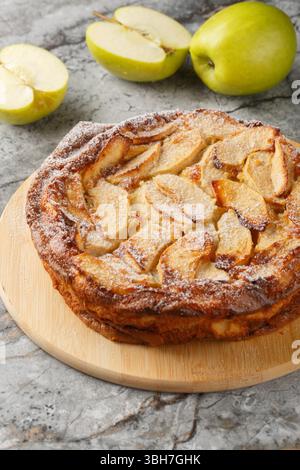 Savoureux clafoutis aux pommes est un dessert français qui combine de tendres tranches de pommes avec un gros plan de pâte douce ressemblant à une crème anglaise sur une table. horizontal Banque D'Images