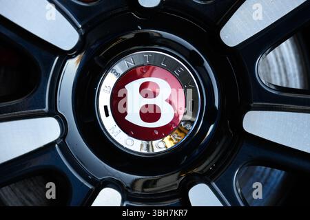 Cette image montre un gros plan d'un écusson de roue Bentley, mettant en évidence l'emblème emblématique B placé dans une jante en alliage haut de gamme, reflétant le lux de la marque Banque D'Images
