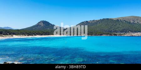 Eau turquoise, montagnes verdoyantes, paysage méditerranéen. Les eaux turquoises éclatantes rencontrent doucement la rive rocheuse sous les montagnes verdoyantes Banque D'Images