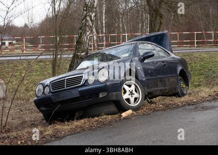 PETRVALD, TCHÉQUIE - 26 JANVIER 2024 : épave de Mercedes-Benz CLK Coupe W208 avec aile endommagée et coffre ouvert dans le fossé Banque D'Images