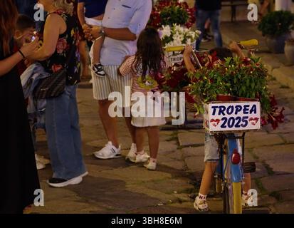 TROPEA, ITALIE - 02 JUIN 2025 - enfant à vélo décoré de fleurs et d'un panneau promouvant Tropea 2025 lors d'un événement public en Calabre, Ital Banque D'Images