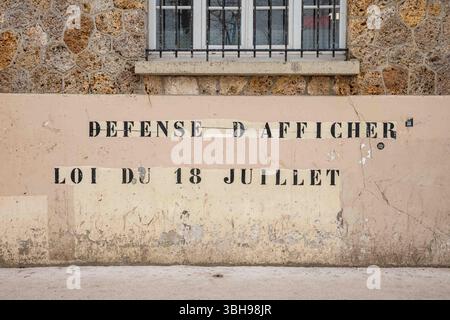 Défense d'Afficher. Loi du 18 juillet. Texte au pochoir sur le bâtiment Avenue Michelet à Saint-Ouen-sur-Seine, France. Banque D'Images