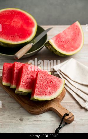 Tranches de pastèque fraîche sur une table en bois rustique lumineux. Banque D'Images