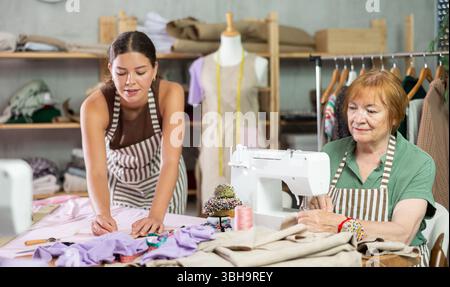 femme couturière fait des marques sur le tissu à côté de la couturière Banque D'Images