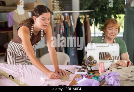 femme couturière fait des marques sur le tissu à côté de la couturière Banque D'Images