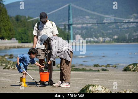 Vancouver, Canada. 8 juin 2025. Des bénévoles ramassent des ordures lors d’un événement de nettoyage des rives lors de la Journée mondiale des océans au parc Stanley à Vancouver, Colombie-Britannique, Canada, le 8 juin 2025. Le 8 juin marquait la Journée mondiale des océans. Des bénévoles ont pris part à un événement de nettoyage du rivage, ramassant les ordures le long du rivage pour sensibiliser la population à la protection de l’environnement marin. Crédit : Liang Sen/Xinhua/Alamy Live News Banque D'Images
