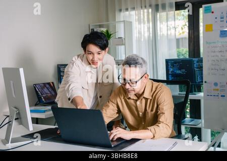 Groupe de senior asiatique dans un développement logiciel collaboratif analysant des organigrammes lors d'une formation bootcamp Banque D'Images
