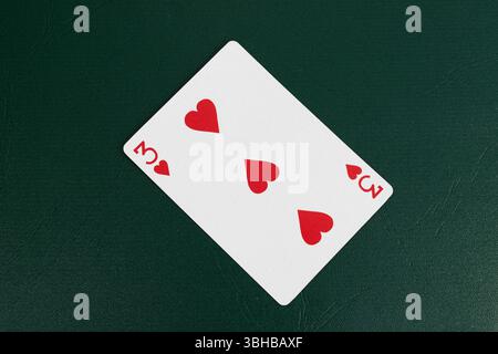 Carte à jouer de trois cœurs sur la table Green Poker - thème Casino Banque D'Images