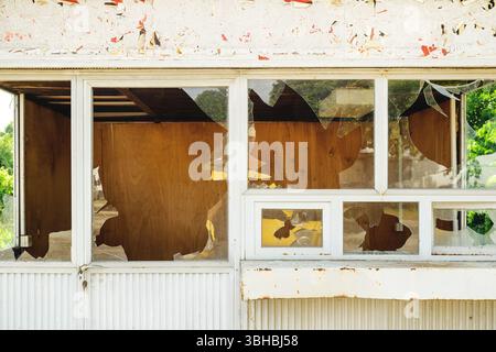 Fenêtres en verre brisées sur un vieux kiosque urbain abandonné, mise au point sélective Banque D'Images