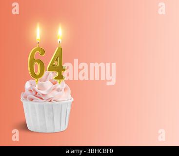 Délicieux cupcake avec des bougies en forme de nombre brûlant sur fond dégradé de corail, espace pour le texte. 64e anniversaire ou autre occasion spéciale Banque D'Images