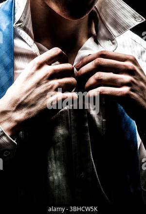 Un homme ajuste son col et sa cravate. Banque D'Images