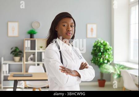 Belle femme afro-américaine confiante médecin, infirmière posant pour caméra debout Banque D'Images