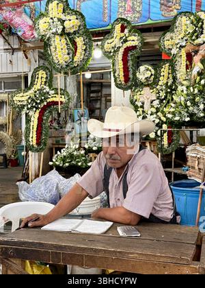 Propriétaire d’une petite entreprise, arrangements de fleurs religieuses, Mercado Jamaica, l’un des marchés publics traditionnels de Mexico. CDMX, Mexique Banque D'Images