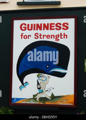 Publicité rétro Guinness Strength avec illustration baleine et plongeur. Kinsale, Irlande Banque D'Images