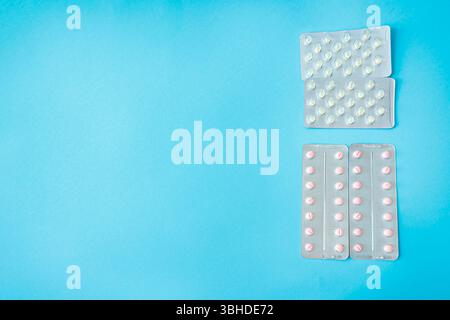 Vue de dessus des pilules roses et blanches dans des blisters sur fond bleu clair. Plan médical conceptuel sur le traitement, la prescription, et la guérison moderne Banque D'Images