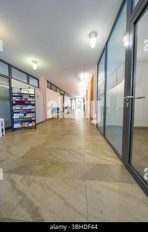 Long couloir moderne avec portes vitrées, porte-brochures et lumière vive, fête de famille à Neubulach, district de Calw, Allemagne, Europe Banque D'Images
