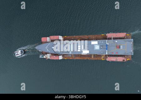 South Queensferry, Écosse, Royaume-Uni. 9 juin 2025. Le HMS Venturer, une nouvelle frégate de type 31 de la Royal Navy, est transporté par barge jusqu'au poste d'amarrage Charles Hammond au port de Leith où il sera flotté. Le HMS Venturer est une frégate à usage général en cours de construction au chantier naval Babcock à Rosyth et une fois débarquée à Leith, elle sera remorquée à Rosyth pour être équipée. Pic ; le HMS Venturer passe sous le pont Forth. Iain Masterton/Alamy Live News Banque D'Images
