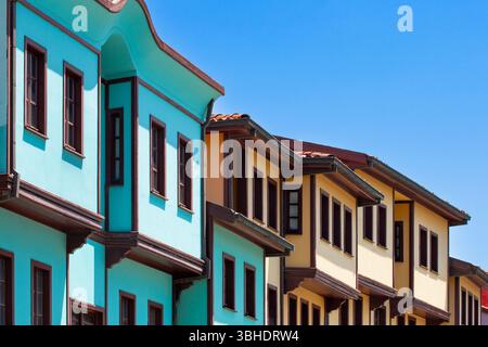 Des maisons traditionnelles de l'époque ottomane avec des façades turquoise et jaune distinctives bordent une rue à Odunpazari, Eskisehir, sous un ciel bleu clair. Le vibra Banque D'Images
