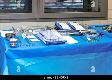 LK Osnabrück, Deutschland 30. Januar 2023 : Im Bild : dieses Bild zeigt einen medizinischen Tisch, der vollständig mit einem blauen, sterilen Tuch abgedeckt ist ein klares Zeichen für die Hygiene und Sterilität in einem Operationssaal oder Vorbereitungsraum eines Krankenhauses. Darauf liegt eine Vielzahl chirurgischer Instrumente, die sorgfältig organisiert und bereitgelegt sind. Man erkennt verschiedene Sets von Skalpellen, Scheren, Klemmen, Pinzetten und andere spezialisierte Operationswerkzeuge, teils in glänzenden Metallbehältern, teils in blauen, stérilen Verpackungen arrangiert. Liens sind Banque D'Images