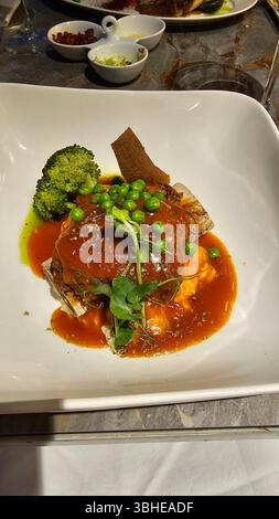 Cuisine américaine. Gros steak grillé juteux sur un os de tomahawk. Bifteck de bœuf avec petits pois servis au restaurant Banque D'Images