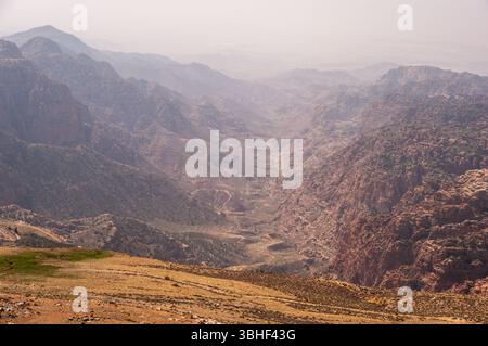 Une chaîne de montagnes avec une vallée entre les deux. La vallée est remplie d'arbres et les montagnes sont couvertes de neige Banque D'Images