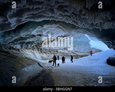 Castner Cave, Alaska - 14 janvier 2022 : les gens et les chiens à l'intérieur de Castner Cave, une grotte de glace en Alaska un jour d'hiver. Banque D'Images