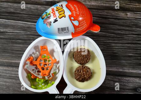 Le Caire, Égypte, 1er juin 2025 : oeuf en chocolat Kinder Joy, un emballage en plastique en forme d'oeuf qui contient deux moitiés scellées. Une moitié contient une garniture crémeuse Banque D'Images