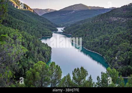 Les eaux sereines reflètent les collines du parc national de Cazorla, mettant en valeur la beauté d'Embalse del Tranco de Beas en Andalousie. Banque D'Images