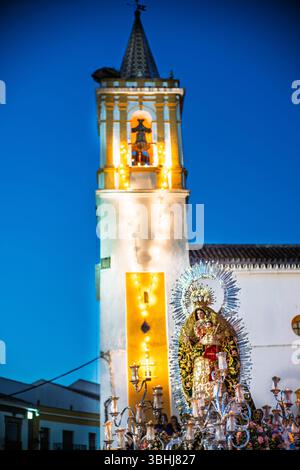 La statue de notre-Dame du Rosaire est exposée sur un char lors d'une procession nocturne à Carrión de los Céspedes, Séville, Andalousie. Banque D'Images