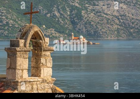 Ville de Perast, église de l'île, 'notre Dame des rochers' avec le clocher de l'église 'notre Dame des anges' situé sur Verige, Stoliv, au premier plan. Banque D'Images