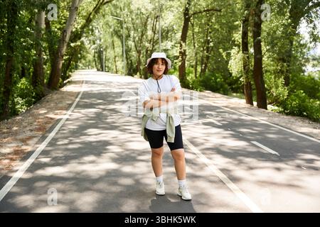 Au cœur de l’été, une jeune femme savoure son temps dehors sur un sentier serein. Banque D'Images