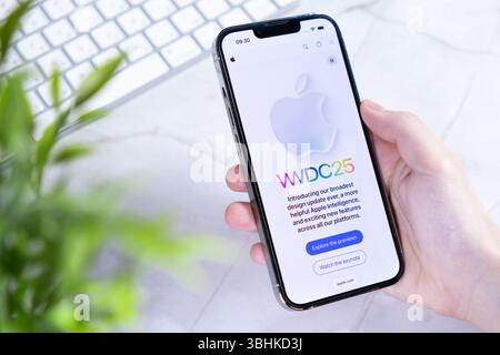 Poznan, Pologne - 10 juin 2025 : gros plan d'un smartphone de pointe tenant la main avec le nouvel iOS 26 et un concept futuriste Liquid Glass Banque D'Images