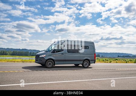 Mini fourgonnette commerciale compacte grise populaire de qualité industrielle pour une utilisation pour les petites entreprises et les livraisons locales fonctionnant sur la route étroite avec meado Banque D'Images